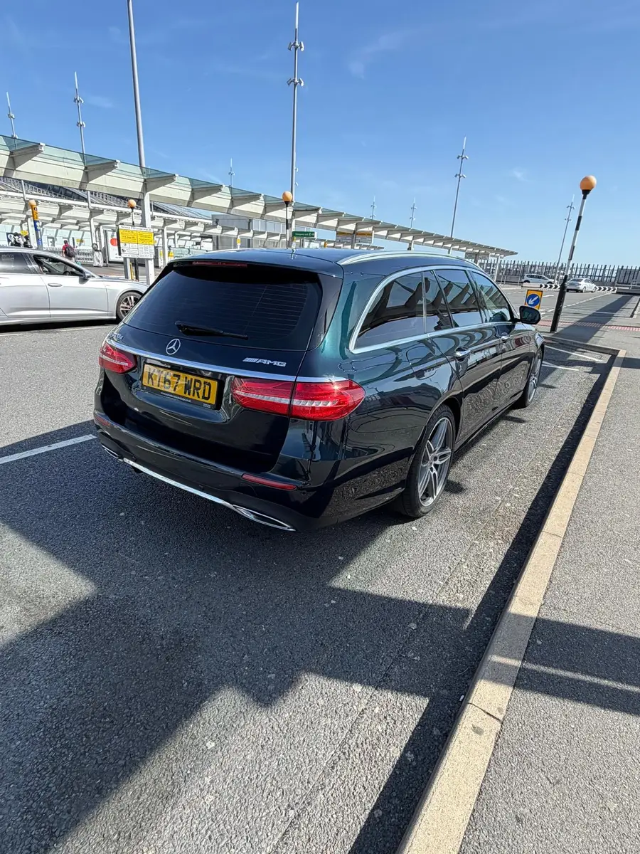 Dark estate car at an airport terminal drop-off